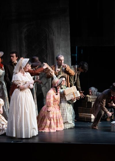 Scene from an opera, featuring a group of people in Regency-era costumes performing on stage.