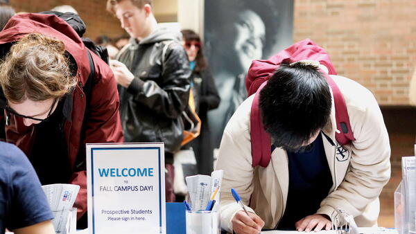 Thumbnail Image for Student registering at a table for Fall Campus Day.