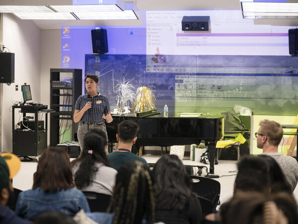Project Coordinator, Adrian Berry stands with a microphone in front of Future Sound 6 participants.