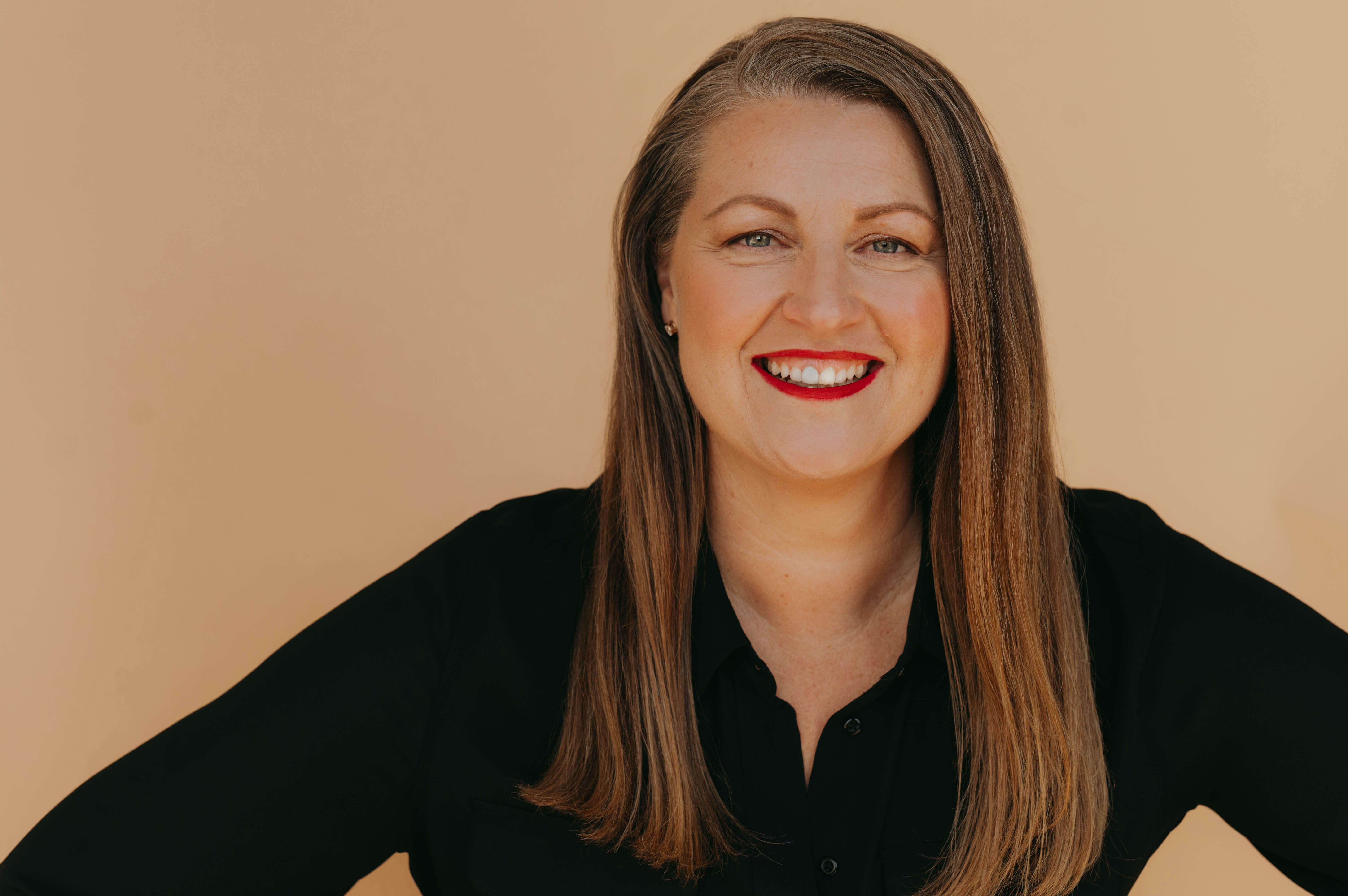Professional headshot of Elizabeth McDonald against a beige backdrop.