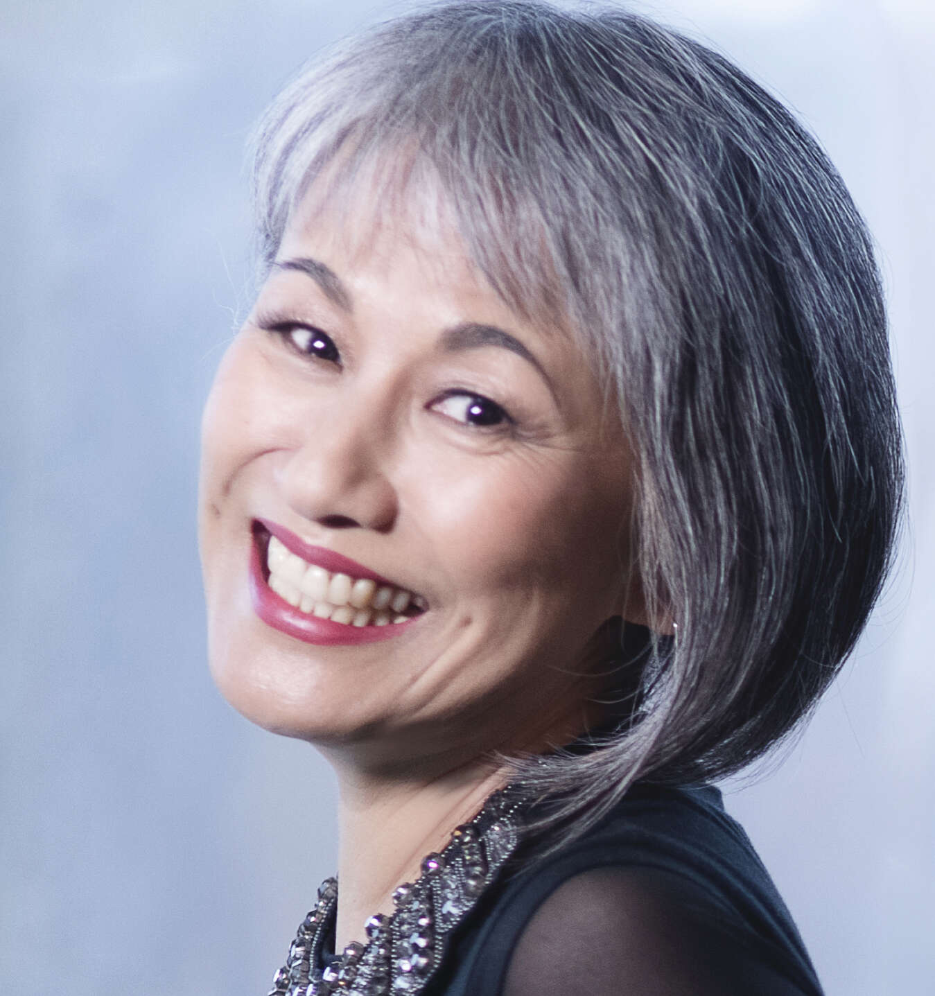 headshot of a person looking over their shoulder and smiling
