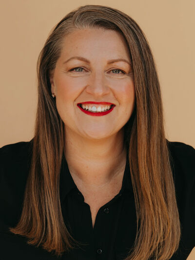 Professional headshot of Elizabeth McDonald against a beige backdrop.