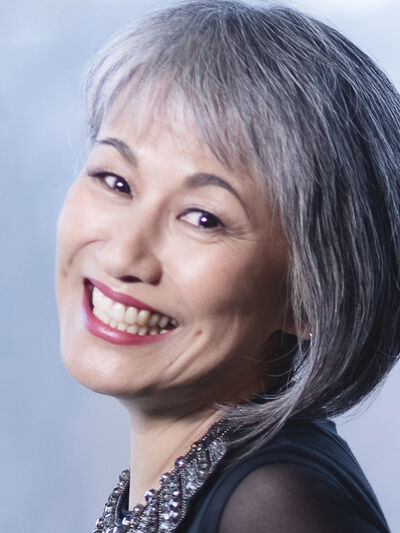 headshot of a person looking over their shoulder and smiling