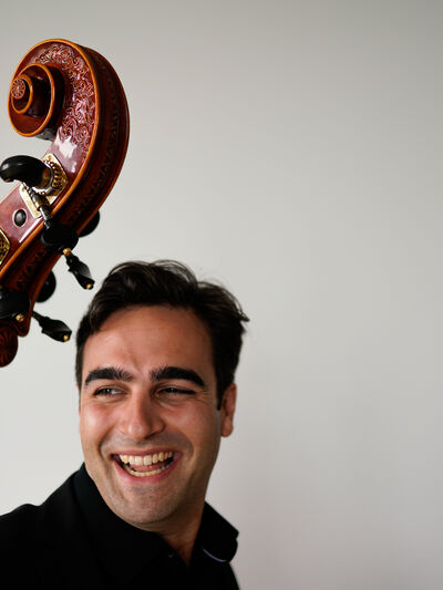 Headshot of Travis Harrison with instrument on left.