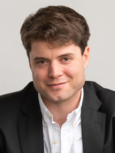 Head shot portrait of Daniel Jordan with grey background