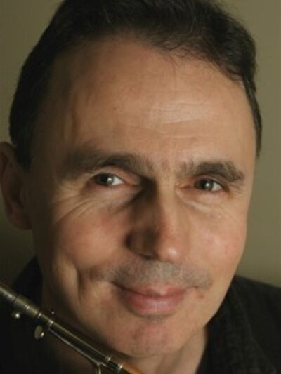 Person smiling while holding a violin bow.