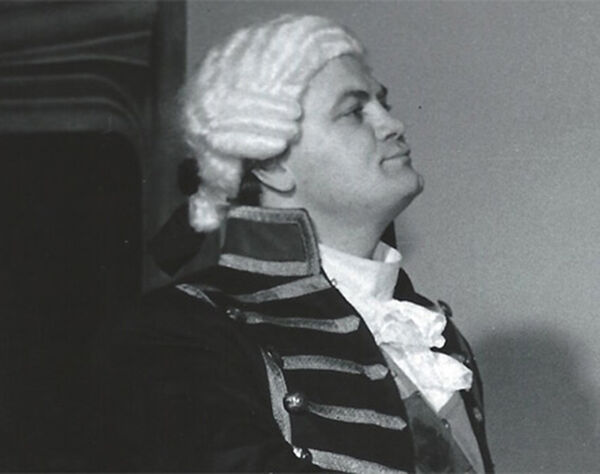 Black and white photo of a person in an Elizabethan costume and wig.